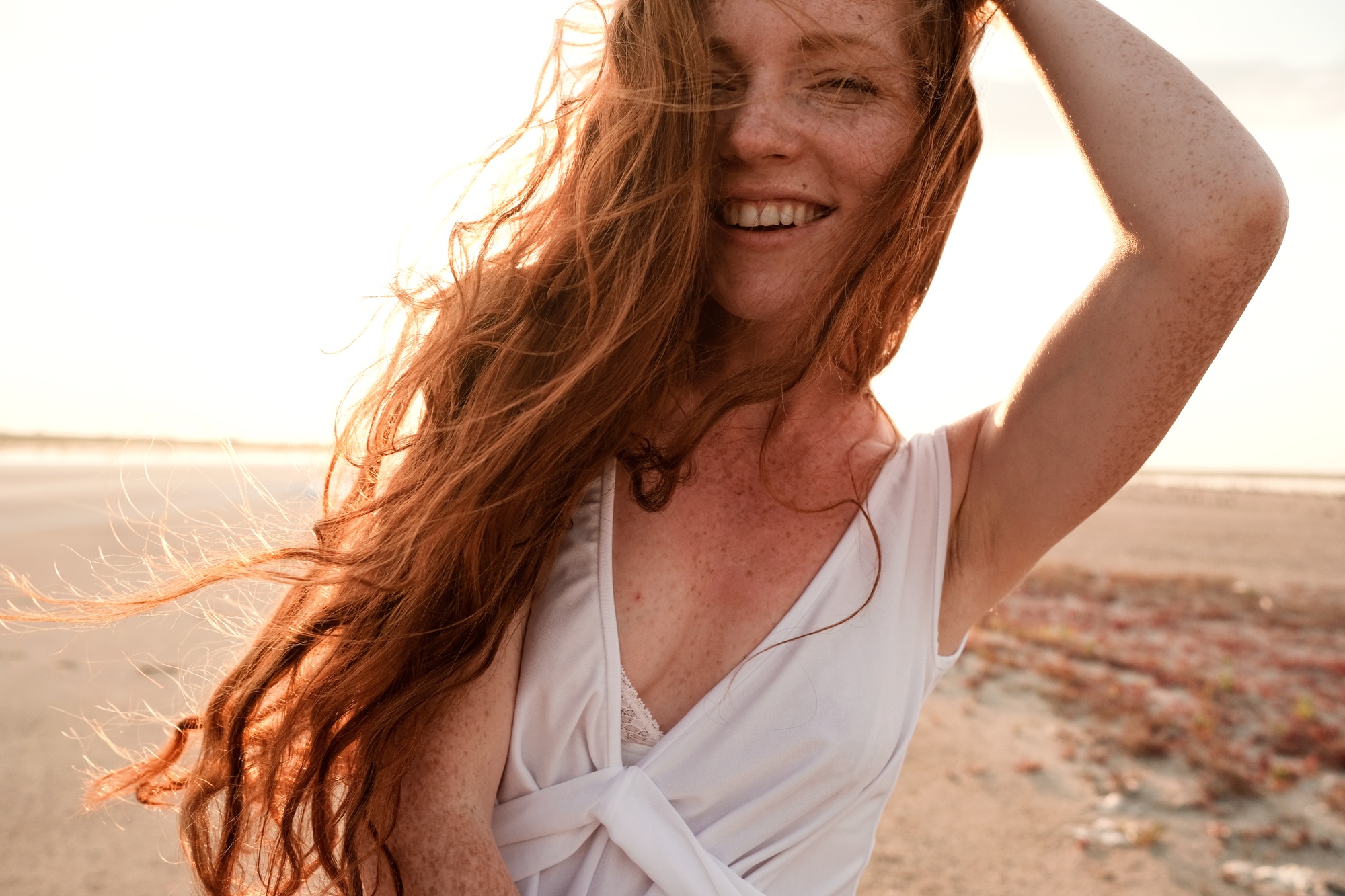 Beautiful young lady with long healthy red hair and cute dress