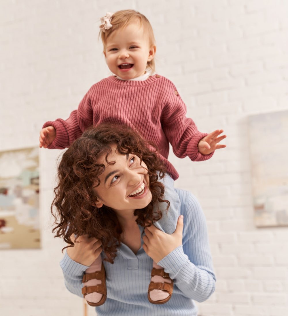 quality time,work and life harmony,cheerful woman with excited baby girl on shoulders,balanced life